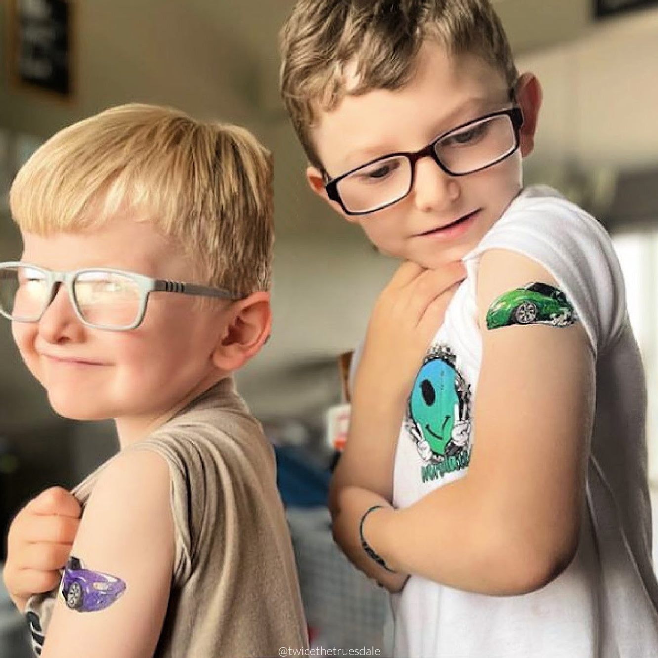 Two children with temporary tattoos of drift cars.