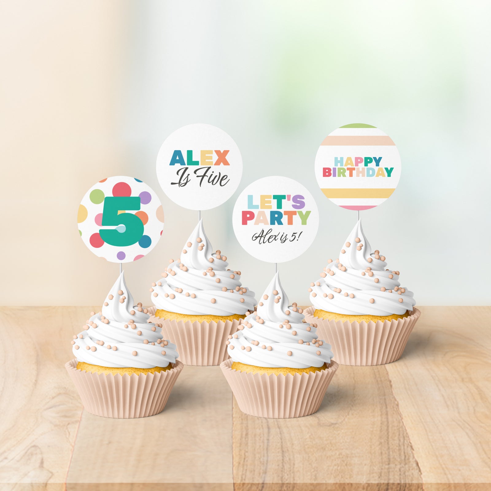 Cupcakes with birthday-themed toppers on a wooden surface