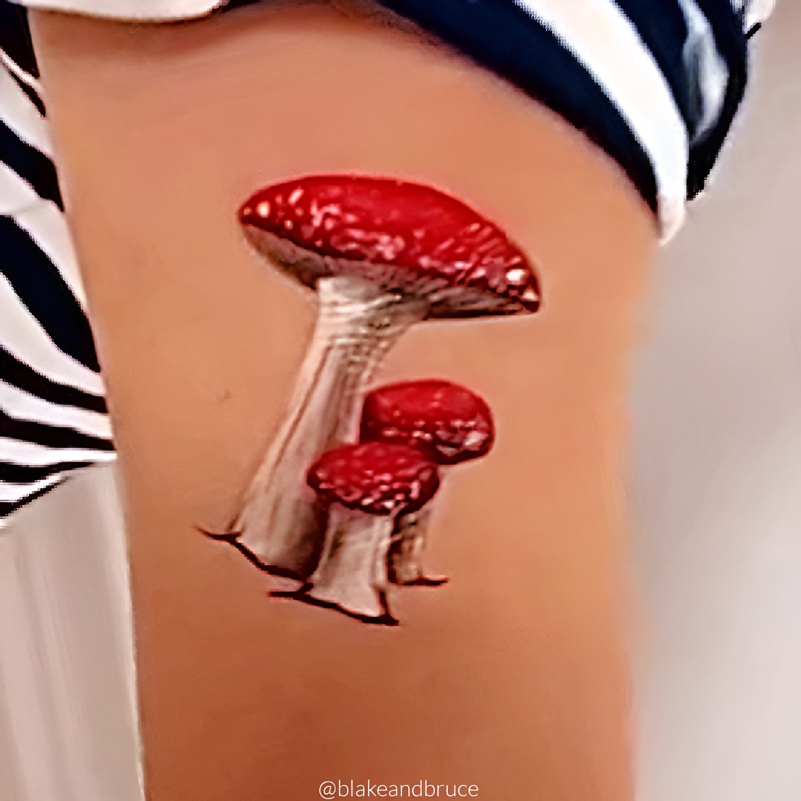 Temporary tattoo of red mushrooms on a child's arm.