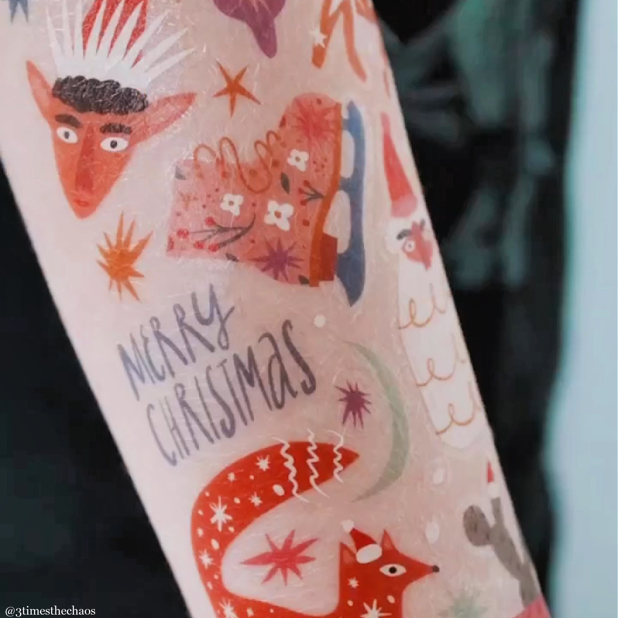 Christmas themed temporary tattoos with colorful designs on a person's arm.