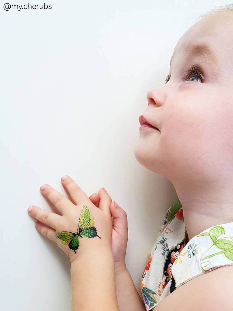 Adorable girl with hand drawn green butterfly temporary tattoo from big kids tattoos set Butterflies from Ducky street. 